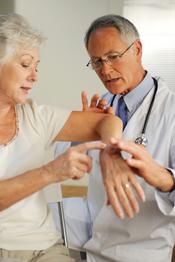 Dermatology - male provider with patient performing skin check on arm