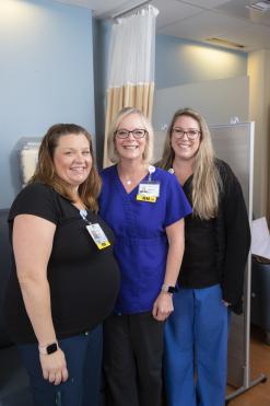 Photo of three infusion suite nurses smiling at camera.