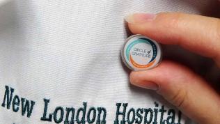 Circle of Gratitude pin being attached to a New London Hospital lab coat
