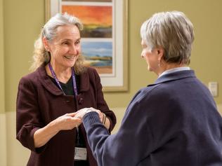 Lin Brown, MD with female patient examining patients hand