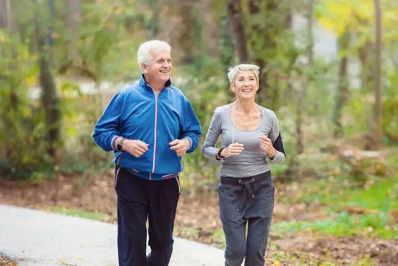 senior man and woman running together for exercise outdoors